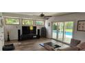 Bright living room with a large sliding glass door to the pool and modern entertainment center at 1550 Chateau Wood Dr, Clearwater, FL 33764