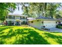 A two-story home with a well-maintained lawn and an attached two-car garage at 1857 Castle Woods Dr, Clearwater, FL 33759