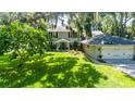 Exterior view of a two-story home featuring a lush green lawn and attached two-car garage at 1857 Castle Woods Dr, Clearwater, FL 33759