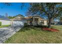 Charming single-story home with lush lawn, mature tree, and a two-car garage at 3017 Minuteman Ln, Brandon, FL 33511