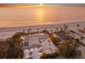 Aerial view of a beachfront property with a house, guest house, mature trees, and a private beach at 3341 Gulf Of Mexico Dr, Longboat Key, FL 34228