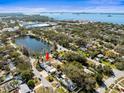 Aerial view of a home near a lake with lush trees and a clear view of the water at 470 Hibiscus N Ln, Dunedin, FL 34698