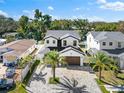 Aerial view of a white two-story home with a dark roof, a spacious driveway, and mature palm trees at 5040 Rena N St, St Petersburg, FL 33709