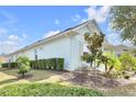 Side view of a well-maintained home with lush green landscaping against a blue sky at 704 Winterside Dr, Apollo Beach, FL 33572