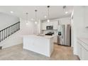 Modern kitchen featuring white cabinets, stainless steel appliances, and center island at 10356 Cross River Trl, Parrish, FL 34219