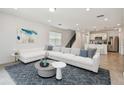 Bright living room with a comfortable white sofa and stylish decor at 10356 Cross River Trl, Parrish, FL 34219