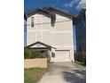 Two-story home featuring a private driveway and a charming covered entryway with lush landscaping at 13253 Boca Ciega Ave, Madeira Beach, FL 33708