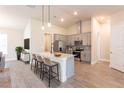 Modern kitchen features an island with seating, stainless steel appliances, and pendant lighting at 16388 Cape Horn Blvd, Punta Gorda, FL 33955