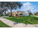 Beautiful home exterior with lush green lawn and mature trees in a well-kept neighborhood at 18822 Quarry Badger Rd, Land O Lakes, FL 34638