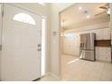 Bright entryway leading to a modern kitchen featuring white cabinets and stainless steel appliances at 2166 Andrews Ct, Dunedin, FL 34698