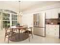 Eat-in kitchen features stainless steel refrigerator, granite countertops and views to the lush backyard at 2166 Andrews Ct, Dunedin, FL 34698