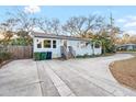 Charming one-story home with blue siding, a paved driveway, and mature trees, ideal for peaceful living at 3307 S Manhattan Ave, Tampa, FL 33629