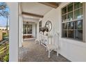 Inviting front porch with white columns, brick flooring, and stylish decor at 3721 Iris N St, St Petersburg, FL 33704