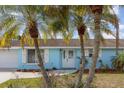 Charming blue house features a well-manicured lawn, attractive landscaping, and decorative shutters at 608 Florida S Cir, Apollo Beach, FL 33572