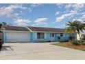 Charming blue house with well-manicured lawn, spacious driveway, and a two-car garage at 608 Florida S Cir, Apollo Beach, FL 33572