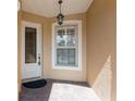 Inviting entryway with decorative glass door, hanging light fixture, and brick-paved porch at 7313 Gaberia Rd, Trinity, FL 34655