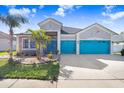 Charming single-Gathering home featuring a three-car garage and eye-catching turquoise doors at 13235 Graham Yarden Dr, Riverview, FL 33579