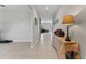 Inviting hallway with light tile flooring and a view into the living area at 1454 Tahitian Sunrise Dr, Plant City, FL 33565
