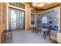 Cozy front porch with stylish seating, a decorative tile wall, and an elegant double door entry at 16410 Ivy Lake Dr, Odessa, FL 33556