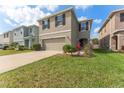 Two story home featuring a two car garage, neutral toned stucco, well-kept lawn and landscaping at 16549 Secret Meadow Dr, Odessa, FL 33556