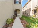 View of the front door of the home and walkway; simple, clean, and neat landscaping at 16549 Secret Meadow Dr, Odessa, FL 33556