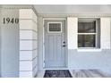 Close-up of the front door with decorative trim, house number '1940,' and a stylish welcome mat at 1940 N Betty Ln, Clearwater, FL 33755