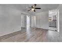 Open living area showcasing wood-look flooring, a ceiling fan, and access to other rooms at 1940 N Betty Ln, Clearwater, FL 33755