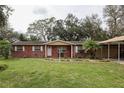 Inviting brick home with white trim, a covered carport, and a green lawn at 204 Amana Ave, Brandon, FL 33510