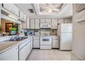 Well-lit white kitchen featuring ample cabinet space, modern appliances, and a convenient pass-through to another area at 2549 Royal Pines Cir # 16H, Clearwater, FL 33763