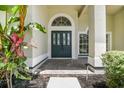 Stylish front entrance with decorative glass door, transom window, and tiled porch at 3616 Cypress Meadows Rd, Tampa, FL 33624