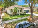 Beautiful one-story home with lush landscaping, healthy green lawn, and mature shade trees at 3616 Cypress Meadows Rd, Tampa, FL 33624