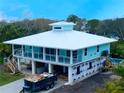 Coastal home with a modern design, showcasing elevated construction and a metal roof at 406 Shore W Dr, Oldsmar, FL 34677