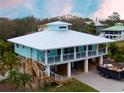 Two-story coastal home on stilts, featuring a spacious design with modern architectural details at 406 Shore W Dr, Oldsmar, FL 34677