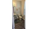 Well-lit half-bathroom featuring modern fixtures, a pedestal sink, and laminate floors at 6134 Fishhawk Crossing Blvd, Lithia, FL 33547