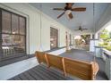 Relaxing covered porch featuring a classic swing, ceiling fans, and neutral gray flooring at 806 E New Orleans Ave, Tampa, FL 33603