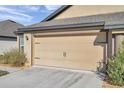 Spacious two-car garage with ample driveway space and lush landscaping at 8949 Southern Charm Cir, Brooksville, FL 34613