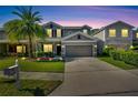 Charming two-story home with beautiful twilight lighting and a well-manicured lawn at 9010 Grand Bayou Ct, Tampa, FL 33635