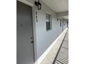 Hallway view showing unit number 303 outside the condo, with tile floor and outdoor lighting at 9815 47Th N Ave # 303, St Petersburg, FL 33708