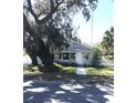 Quaint home with mature trees, manicured lawn, picket fence, and inviting front entrance, showing charm and character at 4905 Court St, Zephyrhills, FL 33541