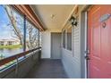 Balcony view with gray plank flooring, a lake view, and a pink entry door at 10263 Gandy N Blvd # 2014, St Petersburg, FL 33702