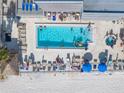 Aerial view of the swimming pool, featuring the building, chaise lounges, and beach at 14700 Gulf Blvd # 405, Madeira Beach, FL 33708