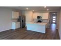 Modern kitchen featuring an island, white cabinets, and stainless steel appliances at 17036 James Trl, Parrish, FL 34219