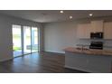 Spacious kitchen with stainless appliances, granite counters, and sliding door access to the patio at 1741 Cobb Trl, Parrish, FL 34219