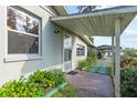 Charming home exterior showcasing a covered entry and landscaped walkway at 19230 Lake Allen Rd, Lutz, FL 33558