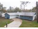Quaint single Gathering home with lush green lawn and a long, paved driveway at 20004 Harvie Ln, Lutz, FL 33558