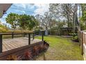 A backyard featuring a wooden deck, a shed with white trim, and a covered pergola, all surrounded by a lush lawn at 2454 15Th N Ave, St Petersburg, FL 33713