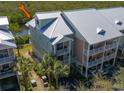 Charming condo complex with manicured landscaping, durable metal roof, and inviting balconies for each unit at 3230 Mangrove Point Dr, Ruskin, FL 33570