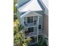 Well-maintained condominium exterior featuring multi-level balconies, lush landscaping, and covered parking at 3230 Mangrove Point Dr, Ruskin, FL 33570