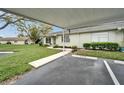 Exterior view of a well-kept home with covered parking and a manicured lawn, showcasing its charming curb appeal at 330 Gloucester Blvd, Sun City Center, FL 33573