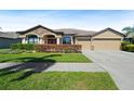 Well-maintained home featuring a stone accent facade and a manicured front yard at 351 Hope Bay Loop, Apollo Beach, FL 33572